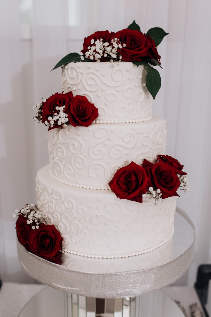 Photo gratuit gâteau de mariage décoré de roses rouges