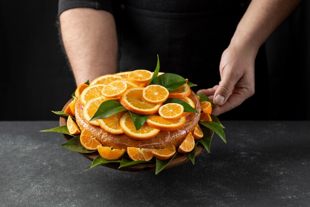Gâteau à l'orange tenu par le chef pâtissier