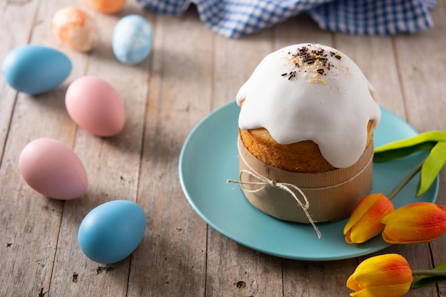 Photo gratuite gâteau de pâques traditionnel, oeufs colorés et tulipes sur table en bois