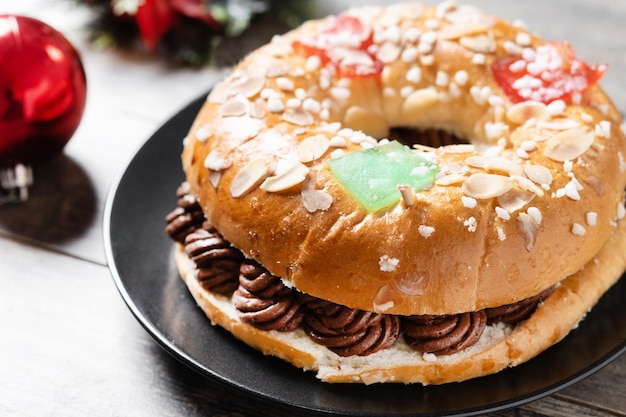 Gâteau de l'Épiphanie individuel roscon de reyes avec de la crème farcie sur une table en bois