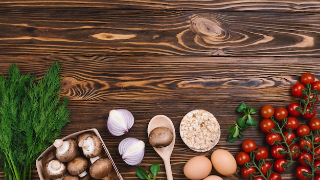 Photo gratuite gâteau de riz soufflé rond avec des légumes frais sur bois texturé