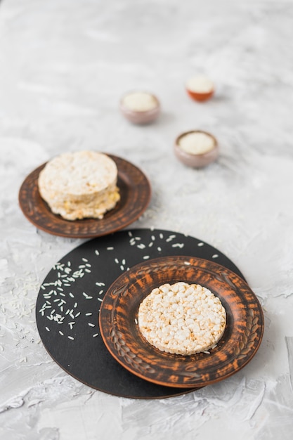 Photo gratuite gâteau de riz soufflé rond et riz sur fond texturé