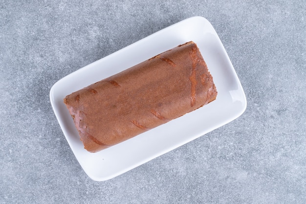 Photo gratuite gâteau roulé au chocolat sur plaque blanche