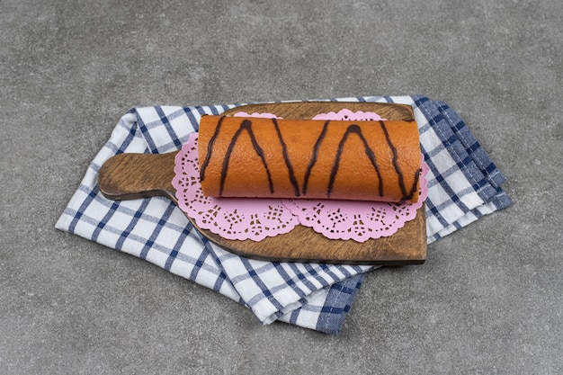 Gâteau roulé sucré sur planche de bois