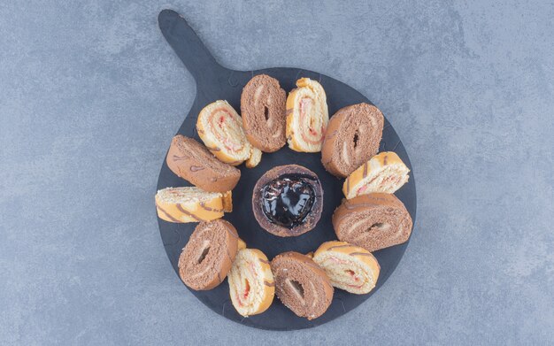 Gâteau roulé en tranches sur le plateau, sur le fond de marbre.