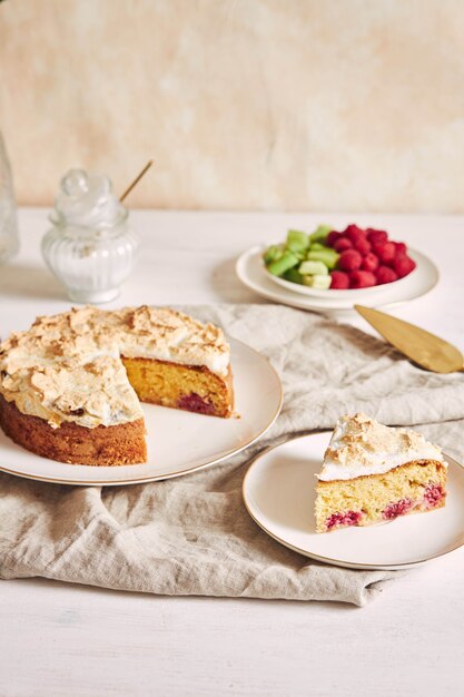 Gâteau savoureux et délicieux avec baiser et framboises sur une assiette