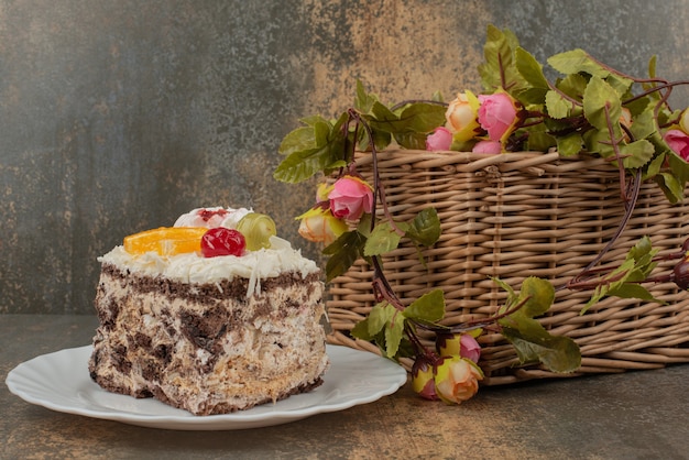 Gâteau sucré avec panier de roses sur table en marbre