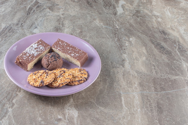 Gaufre au chocolat croustillante et biscuits faits maison sur une assiette en marbre.