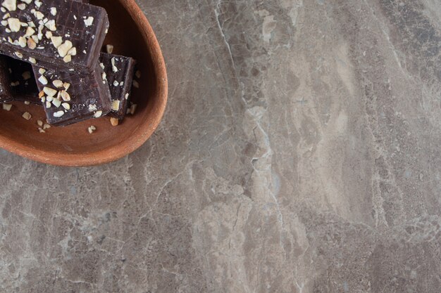 Gaufre au chocolat savoureuse sur un bol en argile sur marbre.