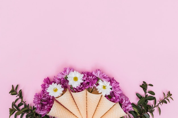 Photo gratuite gaufre cônes avec des fleurs colorées