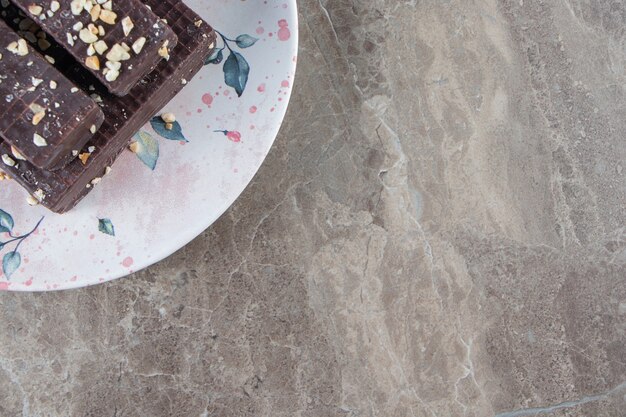 Gaufre enrobée de chocolat sur une plaque sur marbre.