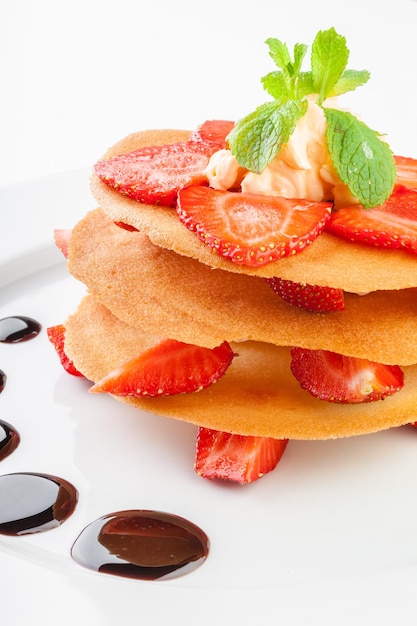 Gaufres à la crème fouettée sauce caramel et fraises isolé sur fond blanc