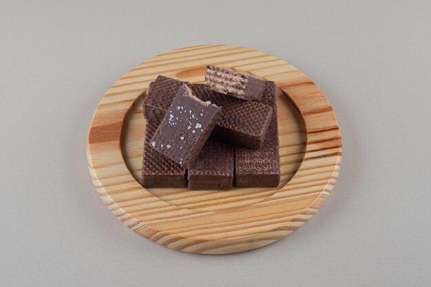 Gaufrettes au chocolat regroupées sur un plateau en bois sur fond de marbre.