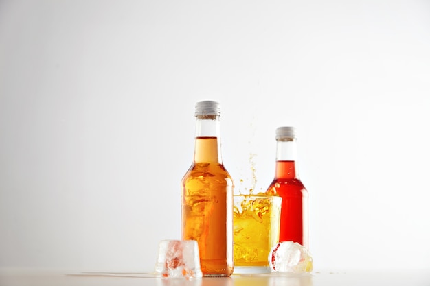 Gelé dans les éclaboussures d'air de limonade du glaçon en feutre en verre avec une boisson savoureuse jaune