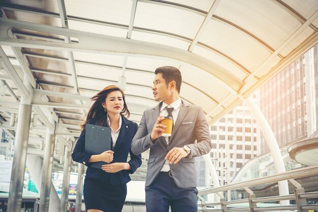 Les gens d&#39;affaires marchent à travers le bureau du passage. Souriant l&#39;un à l&#39;autre.