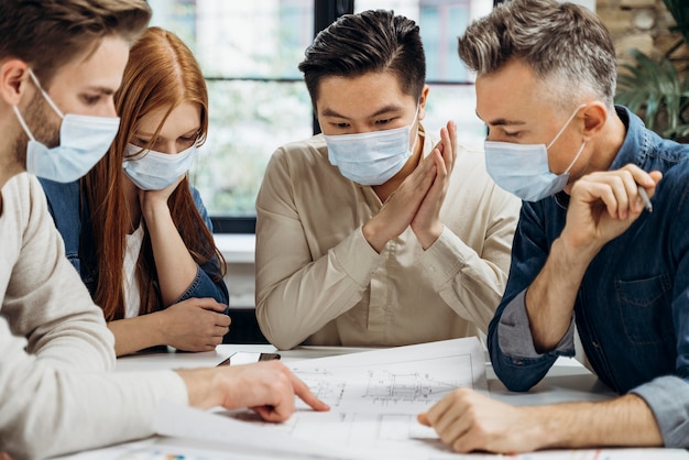 Gens d'affaires portant des masques médicaux au travail