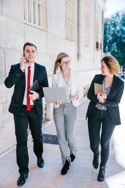 Photo gratuite gens d'affaires positifs avec des appareils numériques