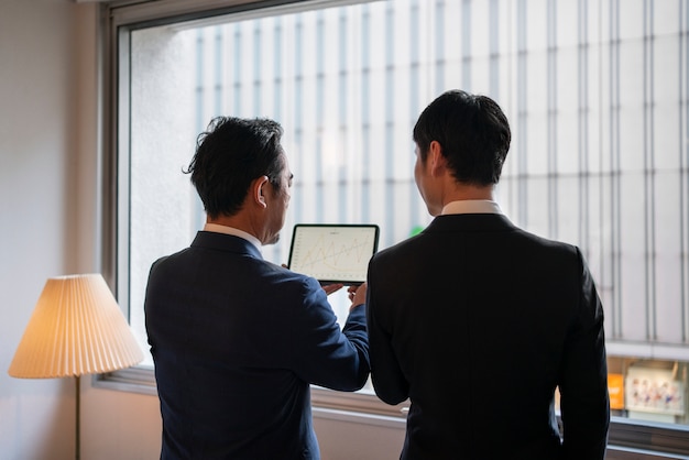 Photo gratuite gens d'affaires travaillant avec la vue arrière de l'ipad