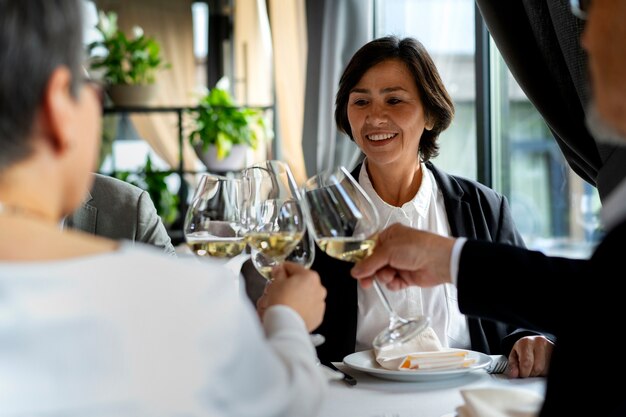 Les gens applaudissent avec des verres à vin dans un restaurant luxueux