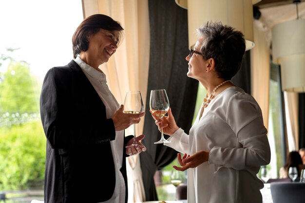 Les gens applaudissent avec des verres à vin dans un restaurant luxueux