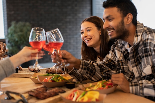 Les gens applaudissent avec des verres de vin lors d'une réunion