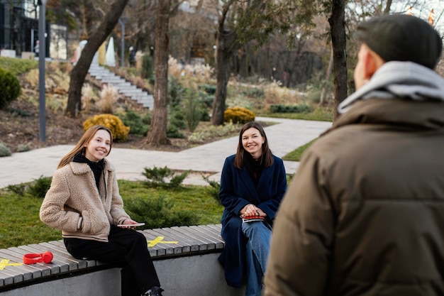 Photo gratuite des gens assis à distance sur un banc