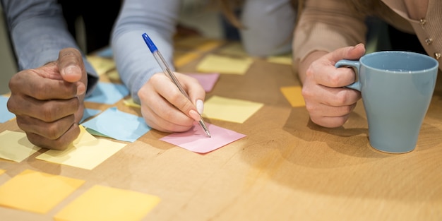 Photo gratuite gens au bureau, écrire des idées sur des notes autocollantes