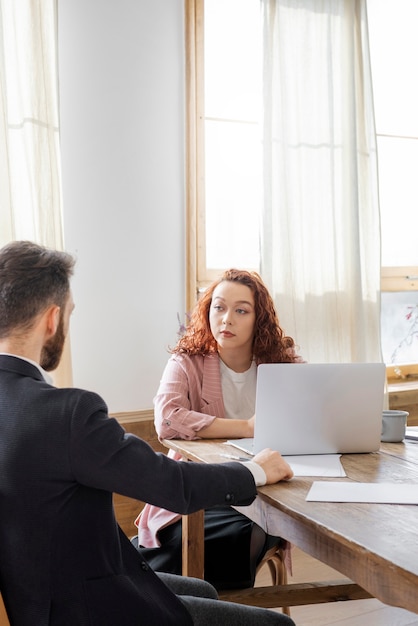 Les gens ayant un débat tout en regardant par-dessus l'ordinateur