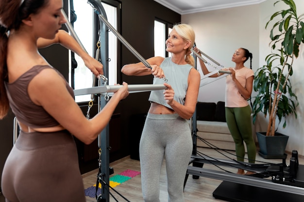 Photo gratuite les gens en classe réformateur pilates exerçant leur corps