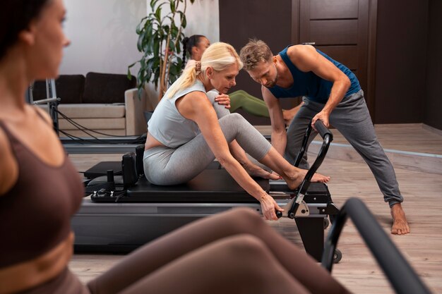 Les gens en classe réformateur Pilates exerçant leur corps