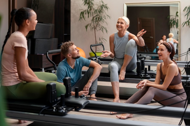 Photo gratuite les gens en classe réformateur pilates exerçant leur corps