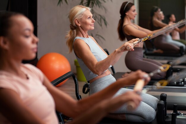 Les gens en classe réformateur Pilates exerçant leur corps