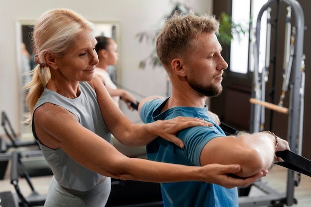 Photo gratuite les gens en classe réformateur pilates exerçant leur corps