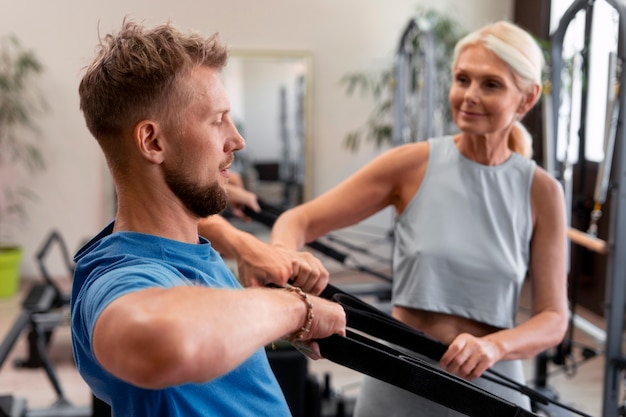 Photo gratuite les gens en classe réformateur pilates exerçant leur corps