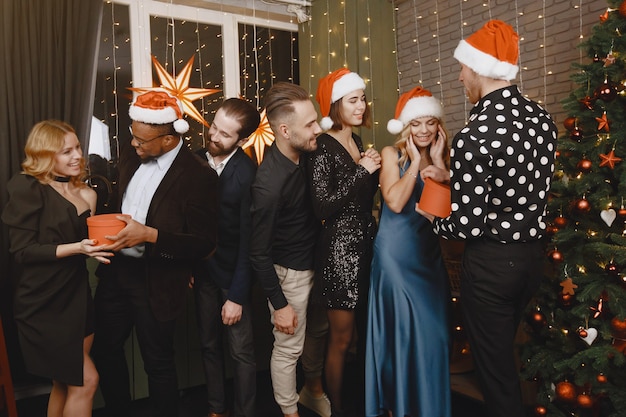 Les gens dans une décoration Christman. Homme en costume noir. Célébrations de groupe Nouvel an.