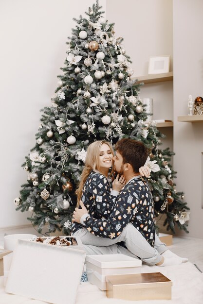 Les gens dans une décoration Christman. Homme et femme dans un pyjama identique. Famille à la maison.