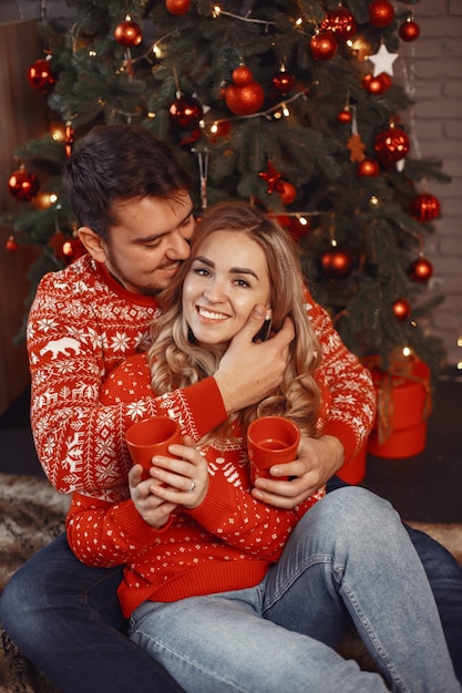 Les gens dans une décoration de Noël. Homme et femme dans un pull rouge.