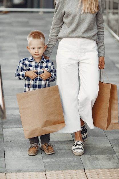 Les gens dans une ville d'été. Mère avec fils. Femme dans un pull gris.