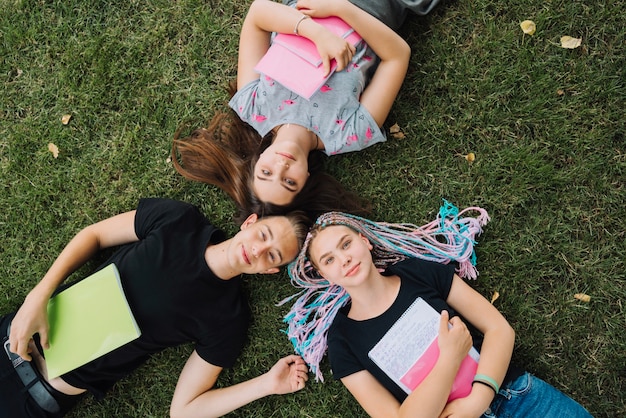 Photo gratuite les gens sur l'herbe avec des livres