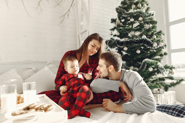 Les gens à la maison. Famille en pyjama. Lait et croissants sur un plateau.