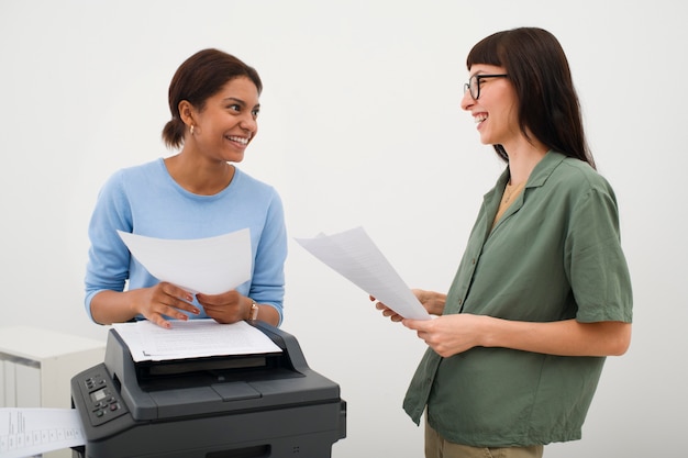 Photo gratuite gens de plan moyen discutant au travail