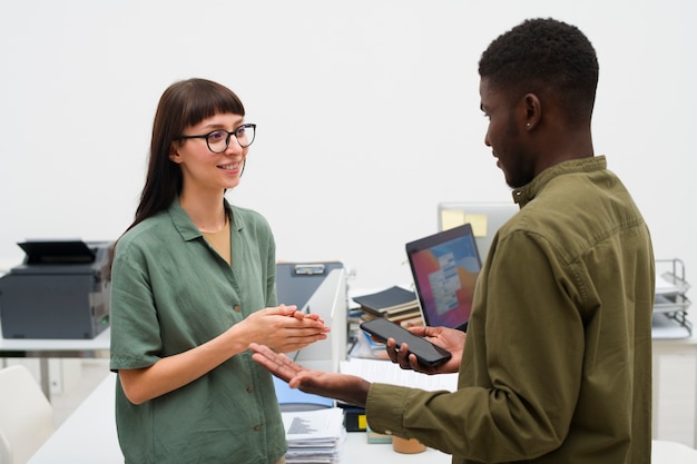 Photo gratuite gens de plan moyen discutant au travail