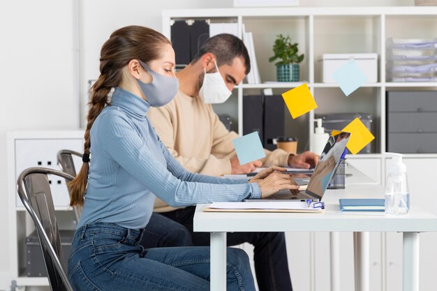 Gens de plan moyen travaillant avec des masques