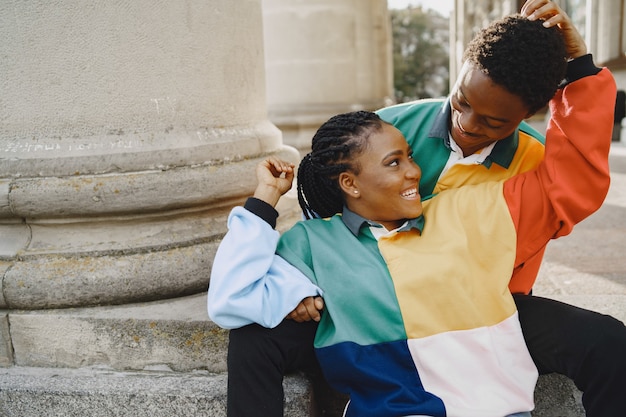 Photo gratuite des gens portant des vêtements identiques. couple africain dans la ville d'automne. des gens assis dans une rue.