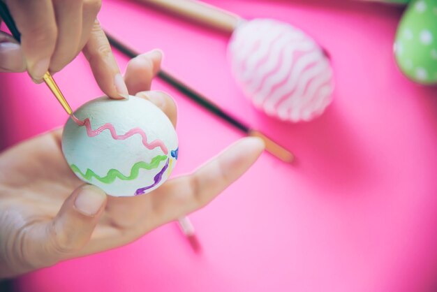 Gens qui peignent des oeufs de Pâques colorés - concept de célébration de vacances de Pâques