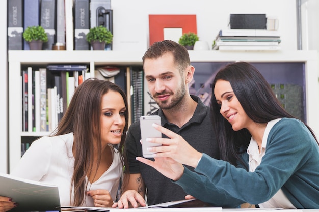 Les gens regardent un smartphone au bureau