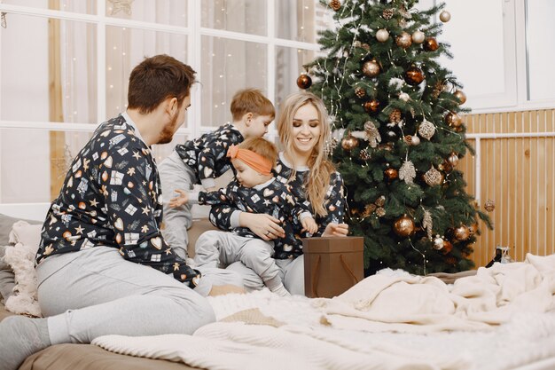 Les gens réparent pour Noël. Des gens assis sur un lit. La famille se repose dans une salle de fête.