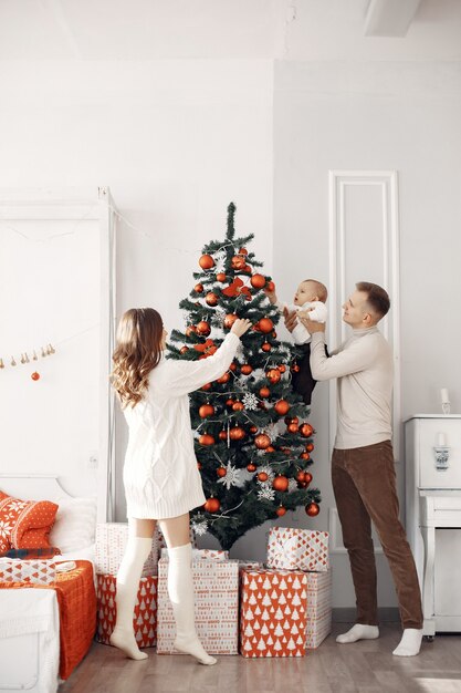 Les gens se préparent pour Noël. Les gens près de l'arbre de Noël. La famille se repose dans une salle festive.