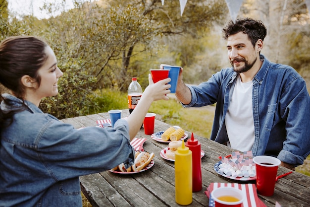 Photo gratuite gens tinter les verres dans le parc