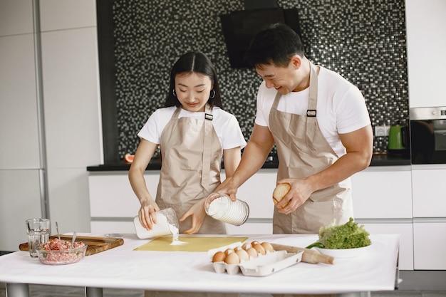 Les gens tout en préparant des boulettes. Les asiatiques en tabliers.